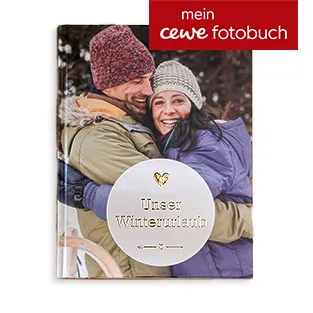 Ein mit Goldfolie verdeltes Fotobuch zeigt ein winterliches Familienbild.